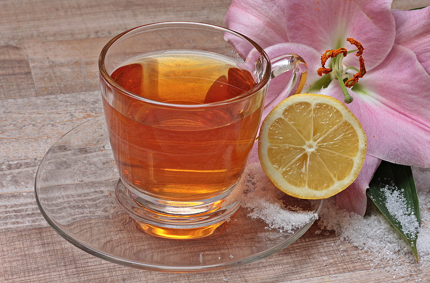 Glass Cup of Tea with Lemon Slice and Pink Lily