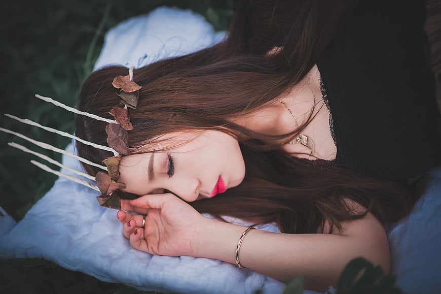 Woman Sleeping with Leaf Crown on White Blanket