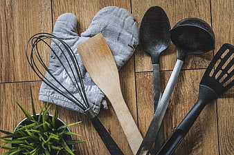 Flat lay of vintage kitchen utensils and oven mitt on rustic wood