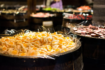 Close-up of yellow and white candy eggs in a wooden barrel