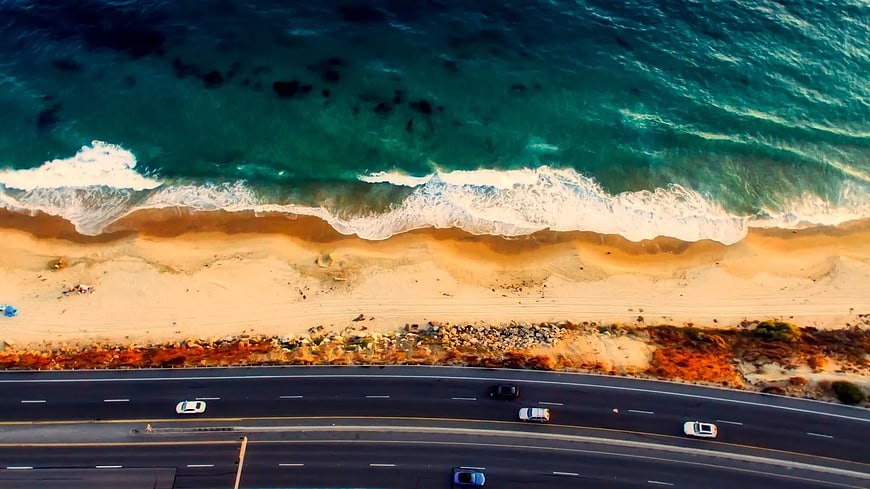 Aerial View of Coastal Highway and Ocean Waves