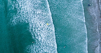 Aerial View of Turquoise Ocean Waves and Surfers