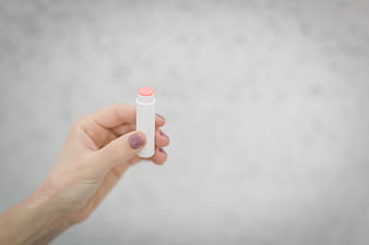 Hand holding pink lip balm with copyspace