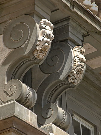 Ornate stone corbels with lion heads on historic building facade