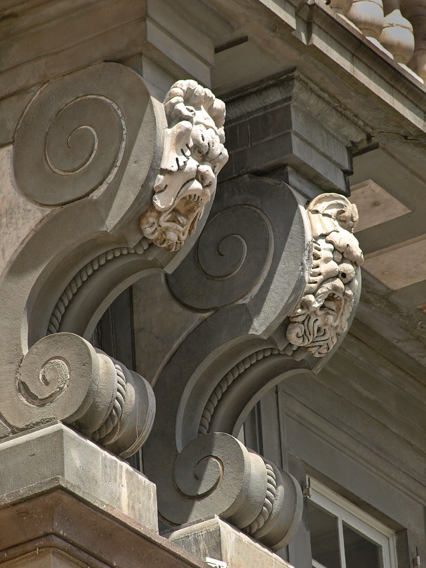 Ornate stone corbels with lion heads on historic building facade