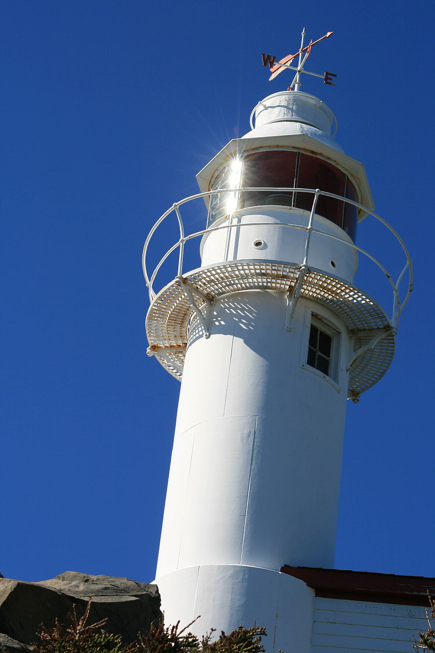White Lighthouse Tower Against Clear Blue Sky