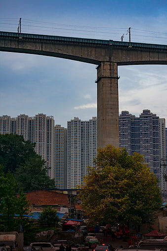 Elevated railway bridge over urban street with high-rise apartments