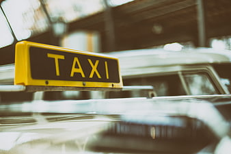 Close-up of yellow taxi sign on vintage car roof