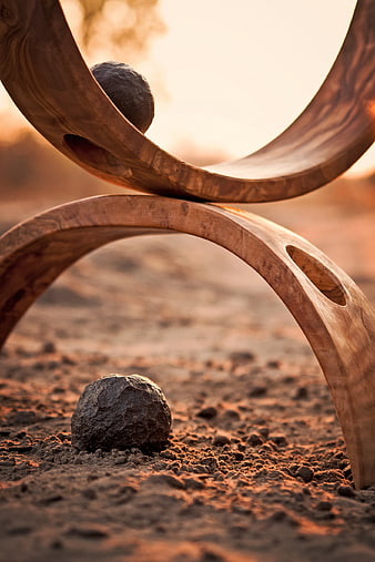 Abstract wooden sculpture with stones in desert landscape