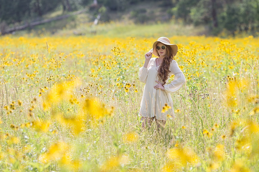 Woman in Straw Hat Standing in Yellow Wildflower Field