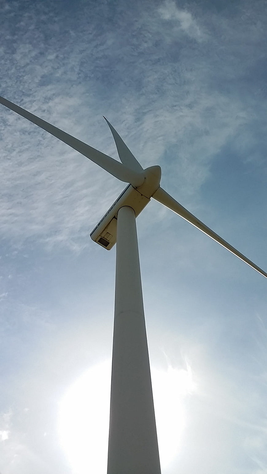 Low angle view of white wind turbine against blue sky