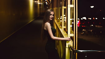 Woman in Green Dress Leaning on Yellow Railing at Night