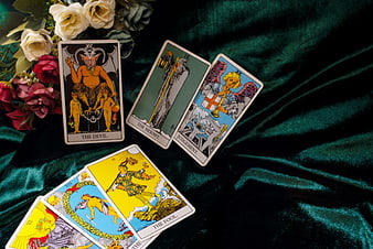 Tarot card reading with roses on dark green velvet background