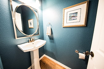Modern blue bathroom interior with pedestal sink and mirror