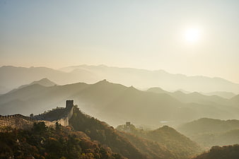 Great Wall of China winding through misty autumn mountains at sunrise