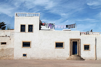 White Moroccan House with Blue Doors and Hanging Laundry