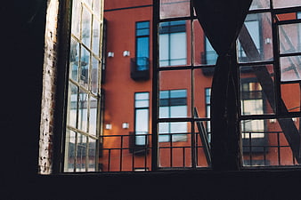 View through industrial window to red brick building
