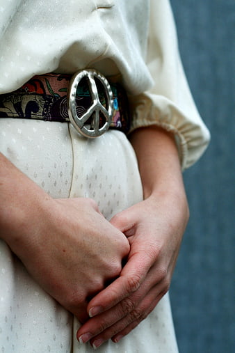 Close-up of woman wearing peace sign belt buckle
