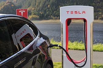 Black Tesla Model X Charging at Supercharger Station by Lake