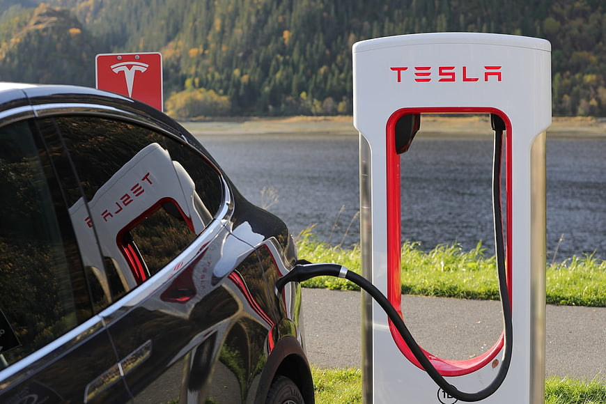 Black Tesla Model X Charging at Supercharger Station by Lake