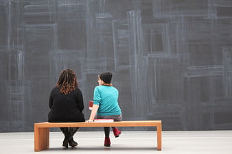 Two Women Viewing Abstract Artwork in Modern Museum Gallery