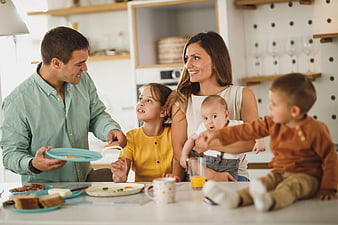 Happy family eating breakfast together in modern kitchen