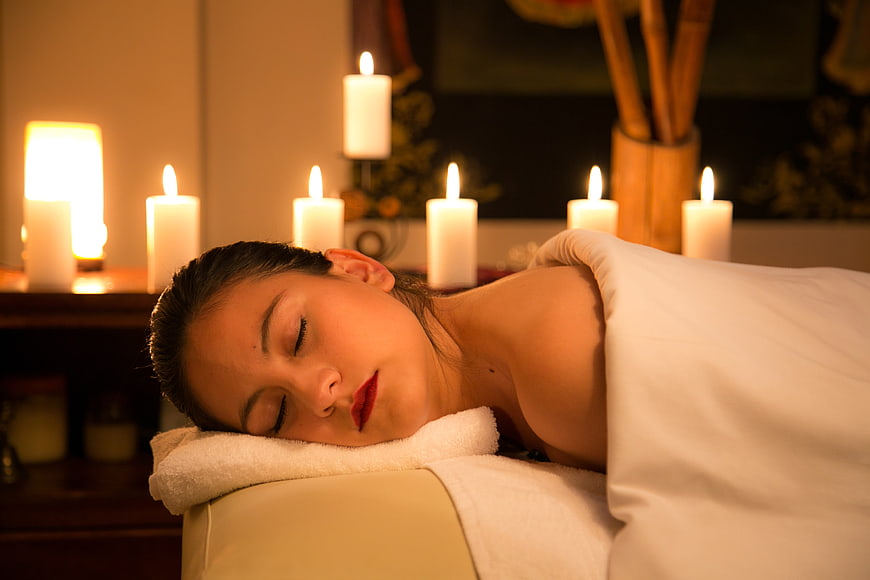 Relaxing woman receiving spa massage with candles