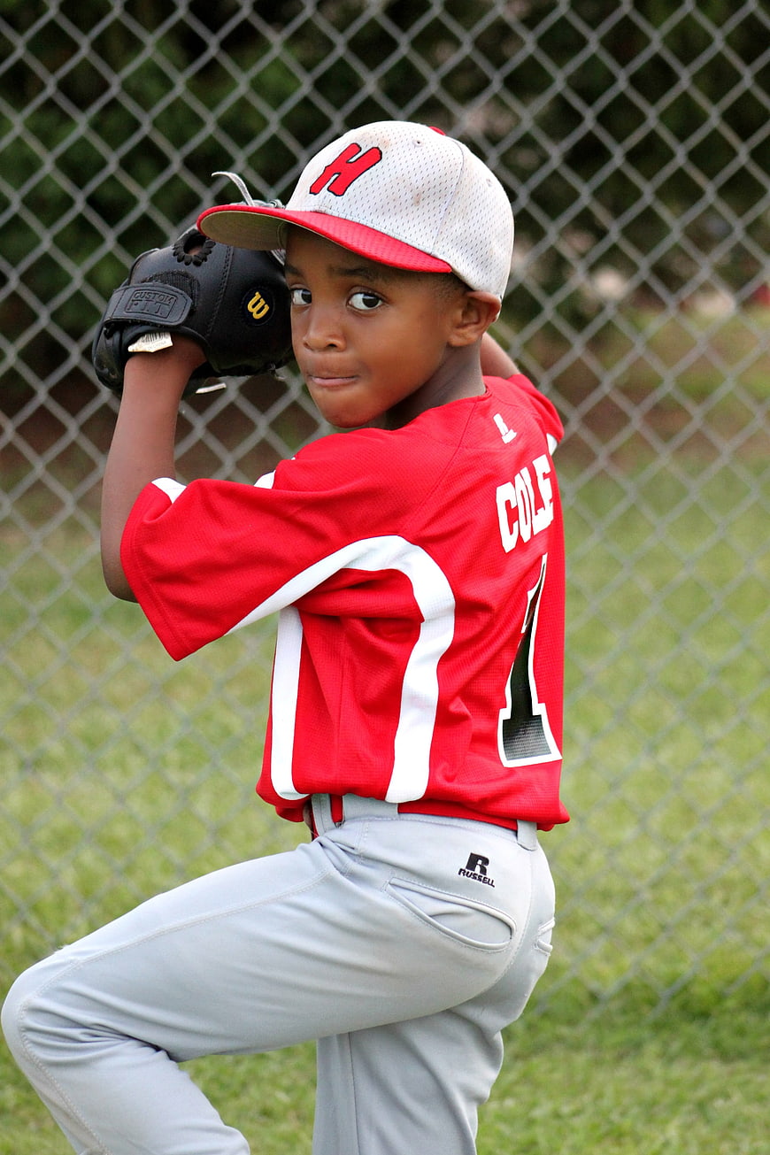 Young African American Baseball Pitcher in Red Jersey