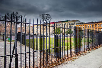 Urban Park Fence with Stormy Sky and City Buildings