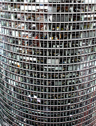 Close-up of curved glass skyscraper facade with office windows