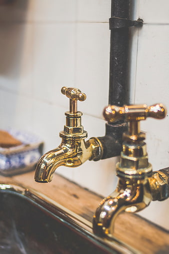 Close-up of vintage brass taps on a rustic sink