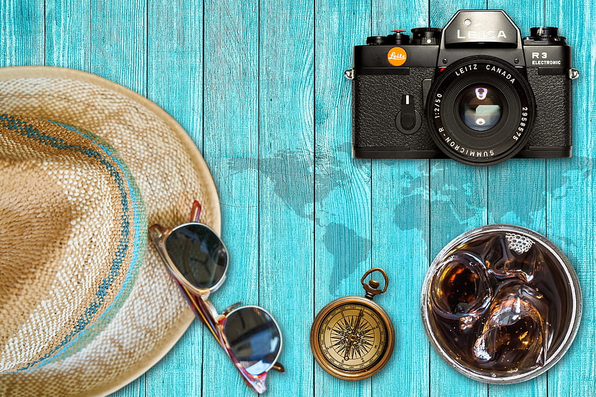 Summer travel accessories on turquoise wooden background