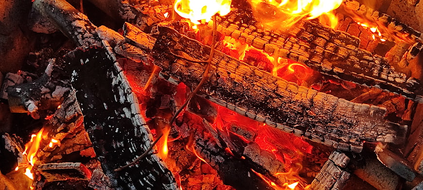Close-up of burning logs and glowing embers in a fire