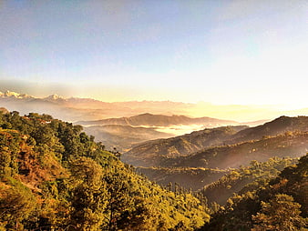 Sunrise Over Misty Mountain Valleys and Forested Hills