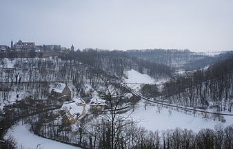Snowy winter landscape with castle and village in valley