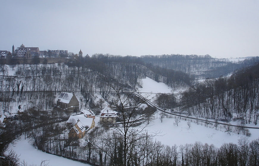 Snowy winter landscape with castle and village in valley