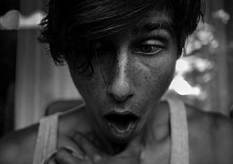 Black and white portrait of a young man with an open mouth