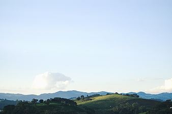 Serene Green Hills and Blue Sky Landscape