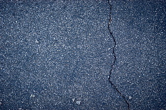 Close-up of cracked asphalt road surface texture