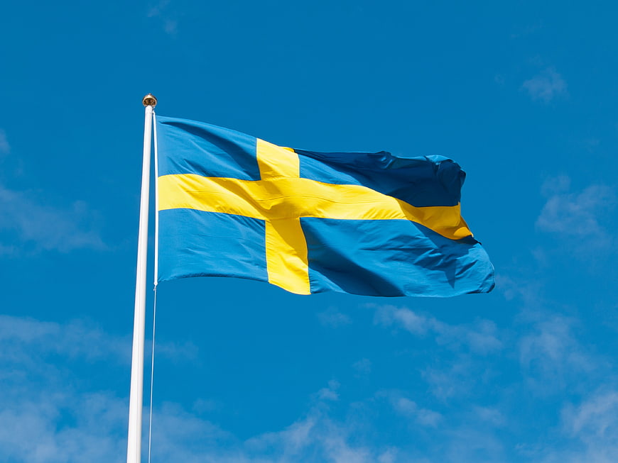 Swedish flag waving against a bright blue sky
