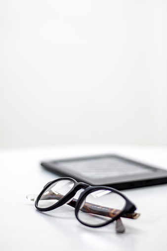 Reading Glasses and E-Reader on White Surface