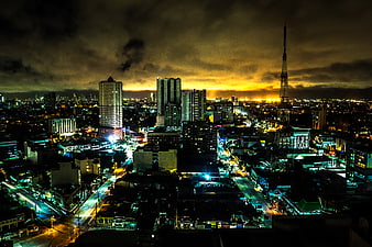Dramatic Night Cityscape with Tower and Cloudy Sky