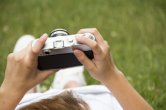 Woman Holding Vintage Camera on Green Grass