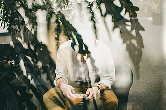 Man with camera seen through leaves