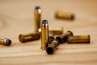 Close-up of brass bullets and casings on wooden surface