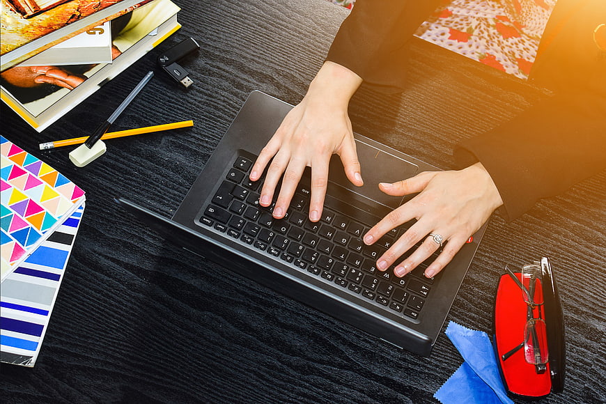 Top View of Woman Typing on Laptop at Desk