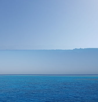 Serene Blue Ocean View with Distant Hazy Mountains