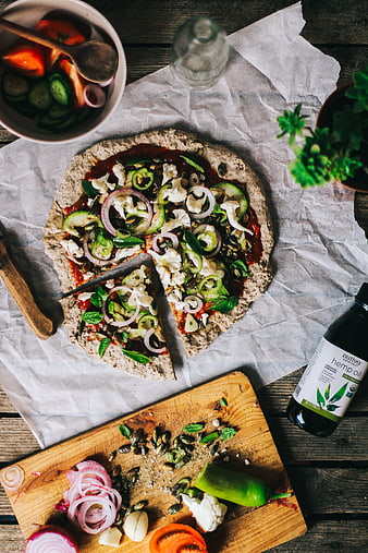 Top view of healthy vegan pizza with fresh vegetables and hemp oil
