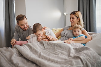 Happy family reading together in bed on a cozy morning
