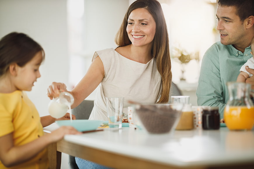 Happy family having breakfast together at kitchen table